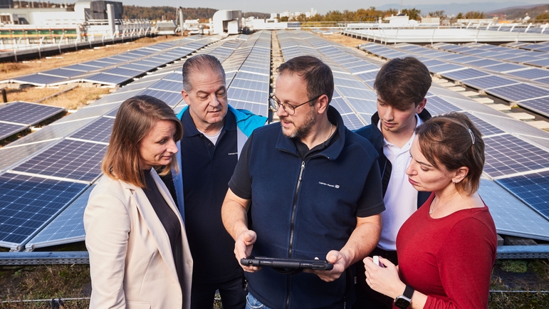 Empleados de Endress+Hauser en el tejado frente al sistema solar.